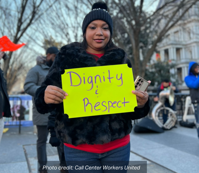 A Black woman worker advocate wears a furry coat and knit cap, holding a bright yellow sign that reads: "Dignity & Respect". photo credit: Call Center Workers United