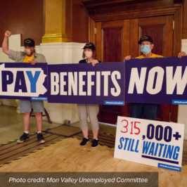 A group of advocates hold up a sign in front of the Governor's Office that reads: "Pay Benefits Now, 315,000+ Still Waiting". photo credit: Mon Valley Unemployed Committee