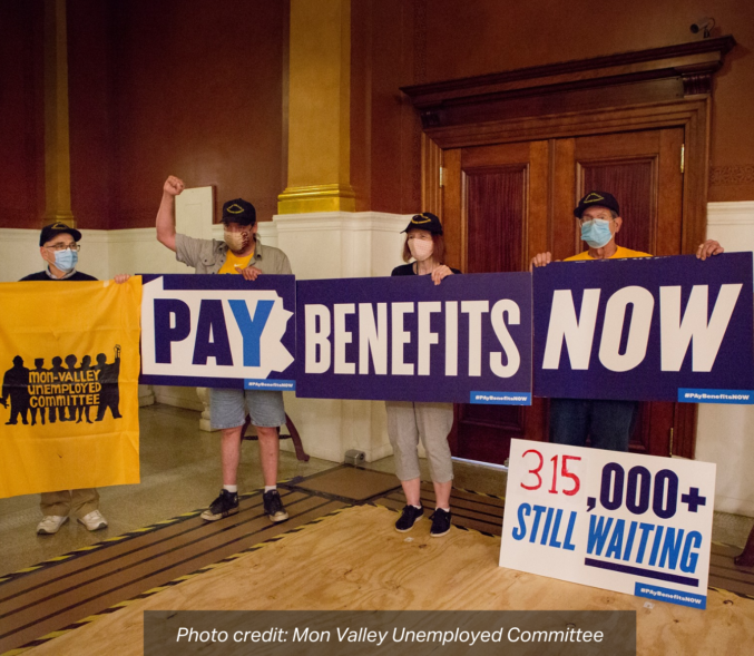 A group of advocates hold up a sign in front of the Governor's Office that reads: "Pay Benefits Now, 315,000+ Still Waiting". photo credit: Mon Valley Unemployed Committee