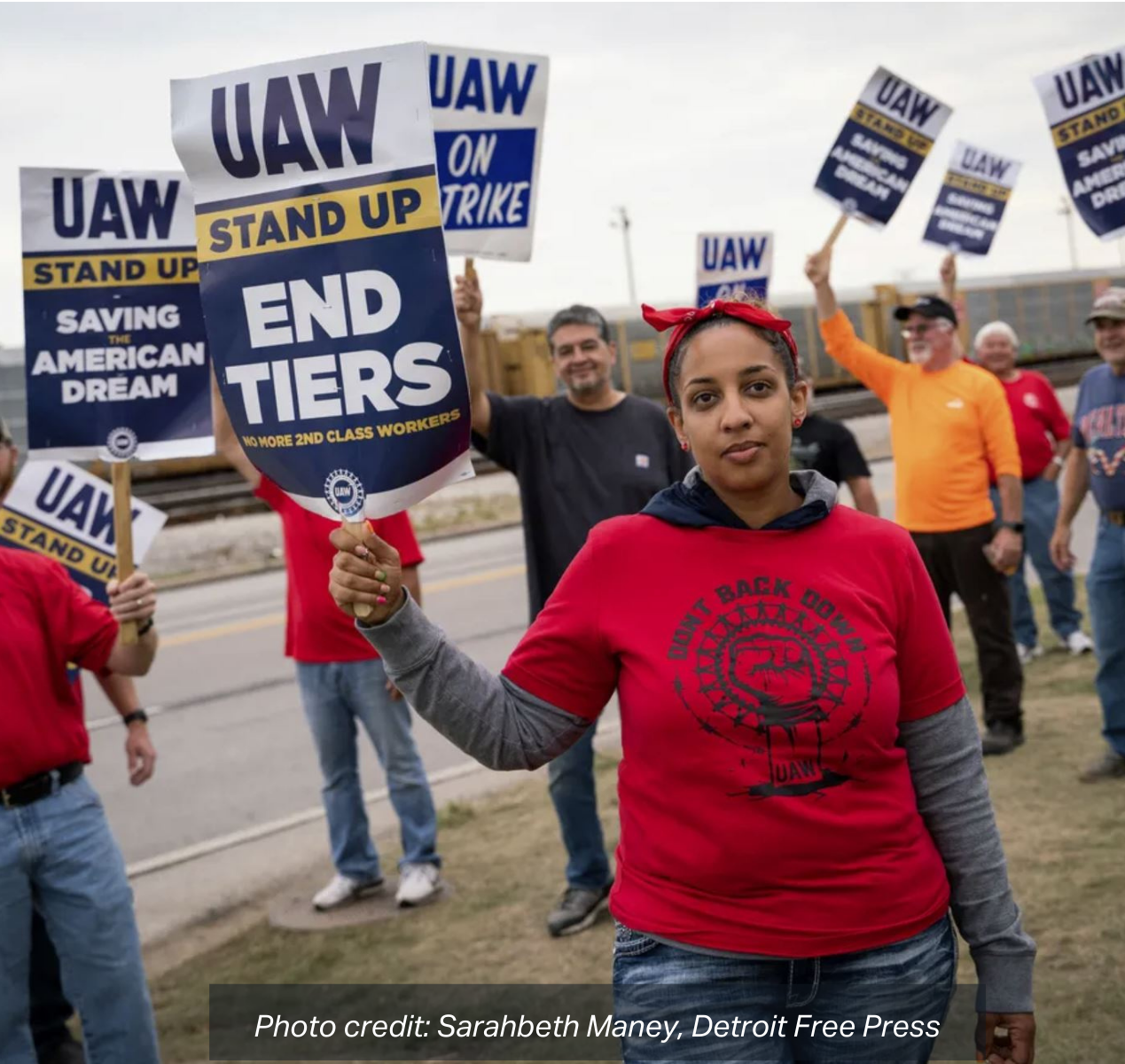 Erika Mitchell, 36, of Toledo, Ohio, center, stands with skilled trades workers outside Stellantis' Toledo Assembly Complex in Toledo, Ohio, on Tuesday during the UAW strike against Ford Motor Co., General Motors and Stellantis. photo credit: Sarahbeth Maney, Detroit Free Press