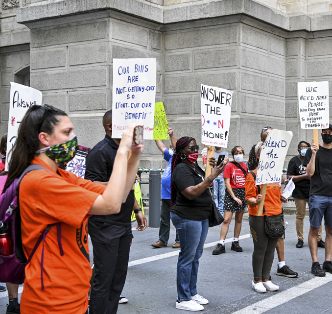 A group of unemployed workers hold signs at an action.